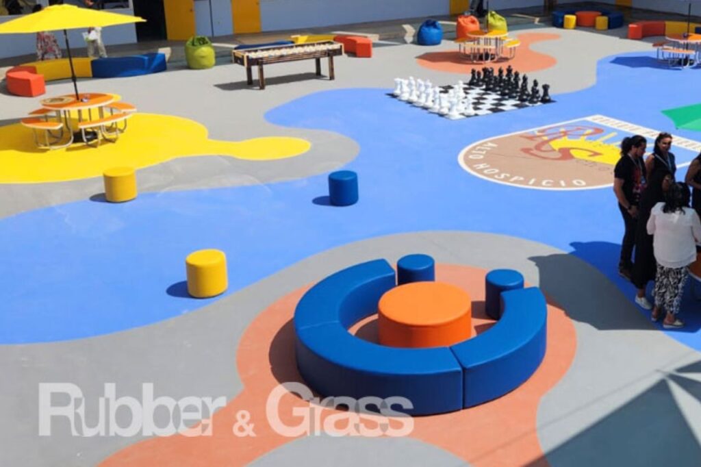 Especificar Pisos de Caucho in situ, especificación técnica piso caucho in situ Chile, caucho EPDM en plaza municipal Santiago, instalación de pavimento caucho reciclado en parque infantil, norma NCh3702 caucho in situ Rubber and Grass, diseño de colores en piso de caucho para plazas, subbase de hormigón para caucho in situ, arquitecto revisando plano de piso de caucho Chile, Rubber and Grass asesoría técnica municipal